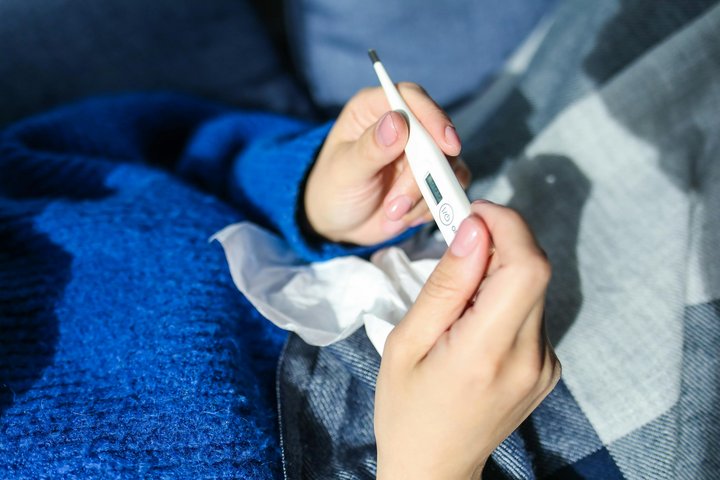 Moteris rankose laiko termometrą